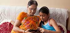 Woman and young girsl sitting looking at tablet - resized for Age UK.jpg