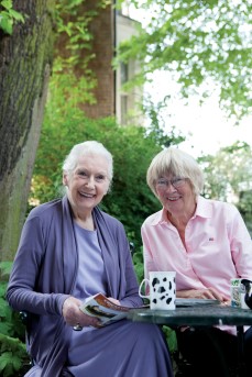 Older woman seated with befriender both smiling