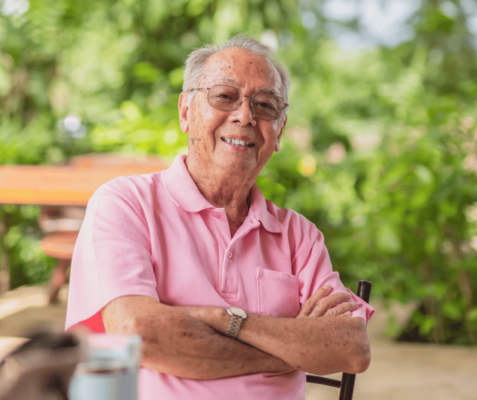 Older man smiling sitting on a bench