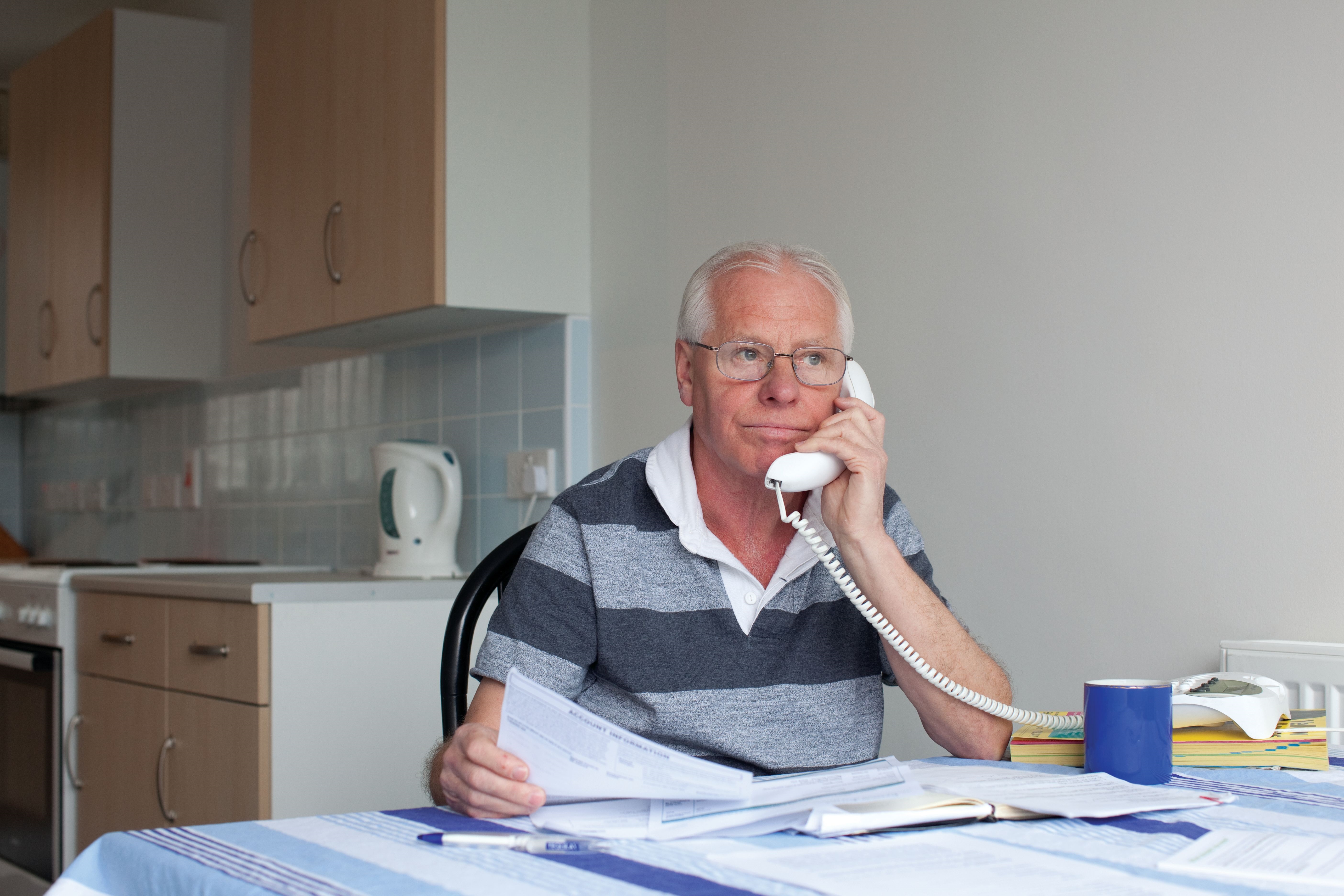 man on phone with paperwork