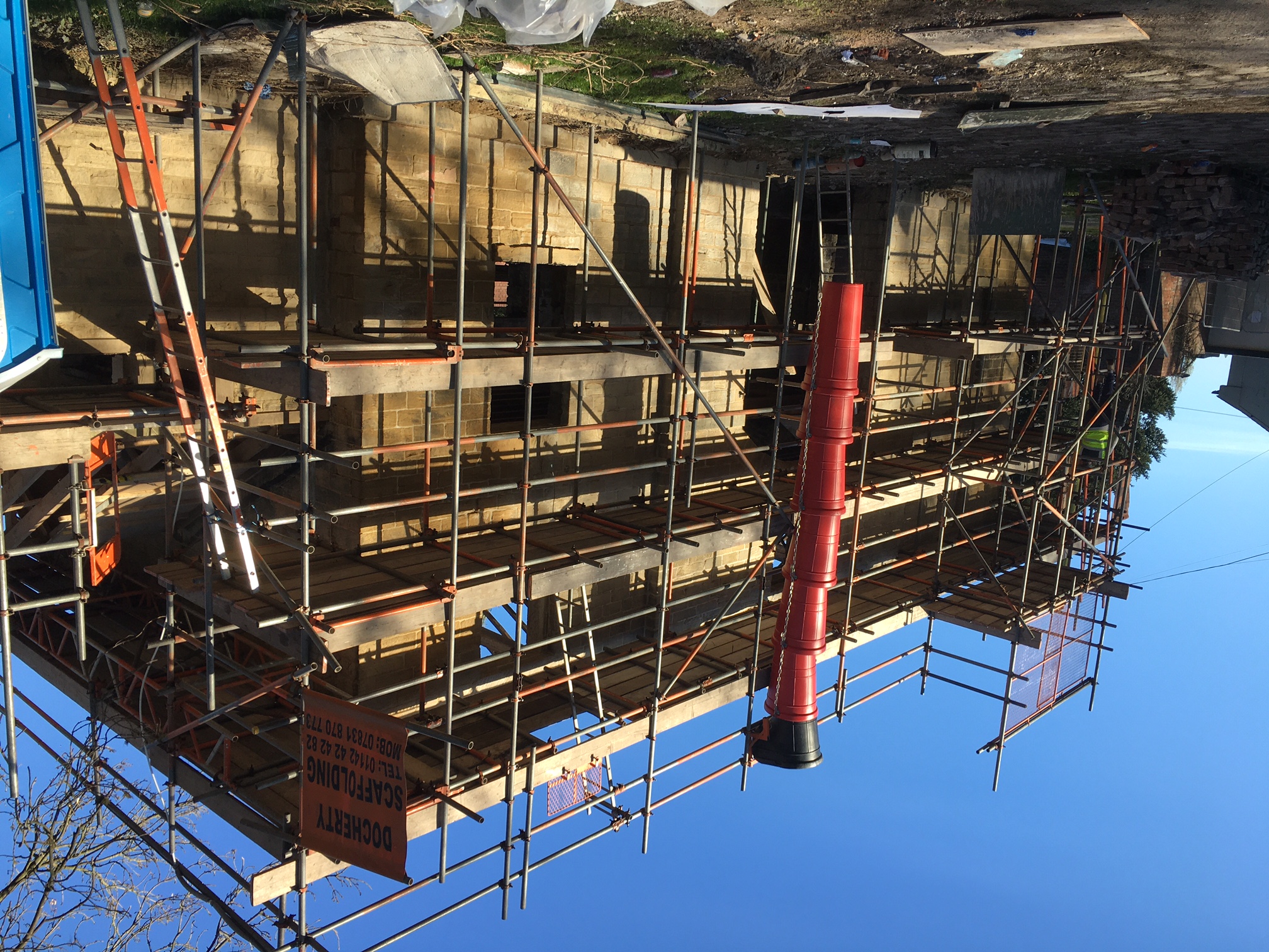 The image shows the outside of the Coach House building surrounded by scaffolding as the building work continues 