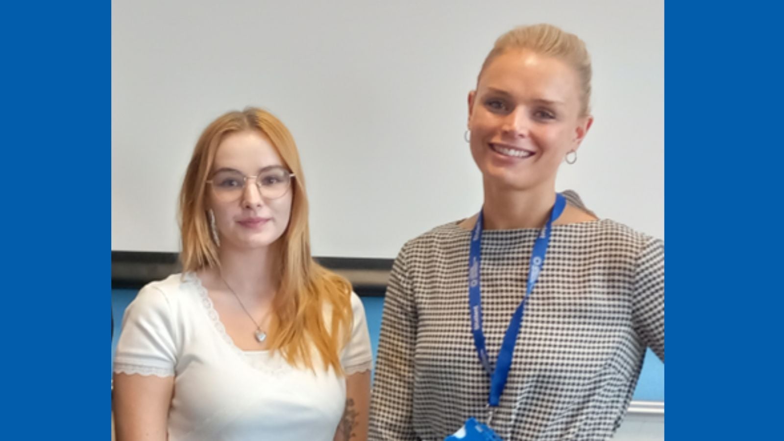 two women standing side by side smiling