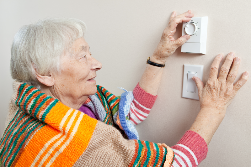 Woman turning up thermostat