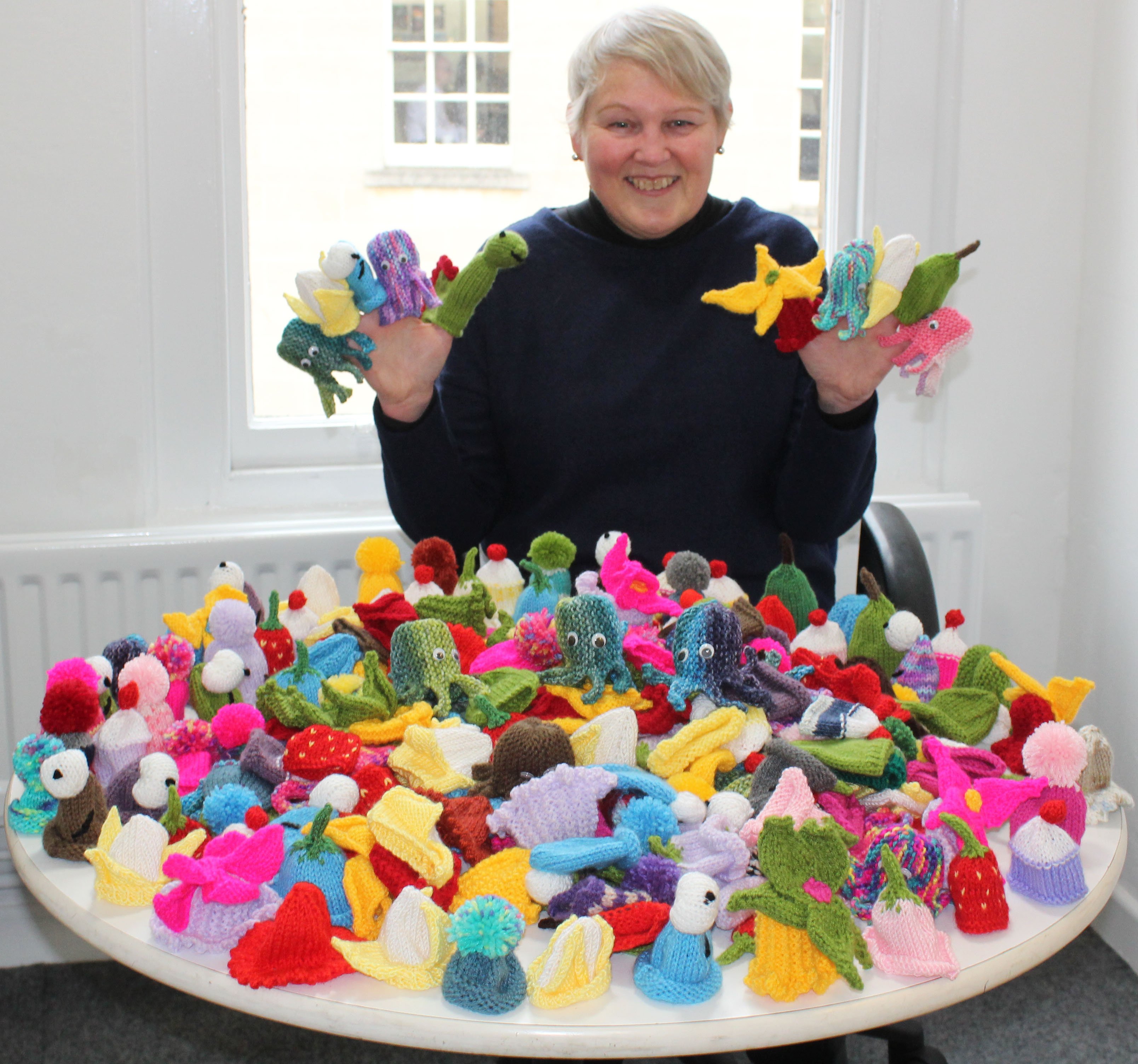 Knitter Wendy Long with the hats she made