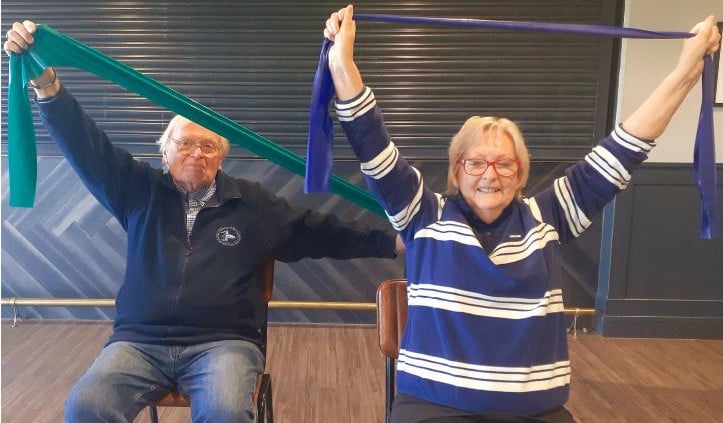 Two over-50s enjoying exercising with resistance bands