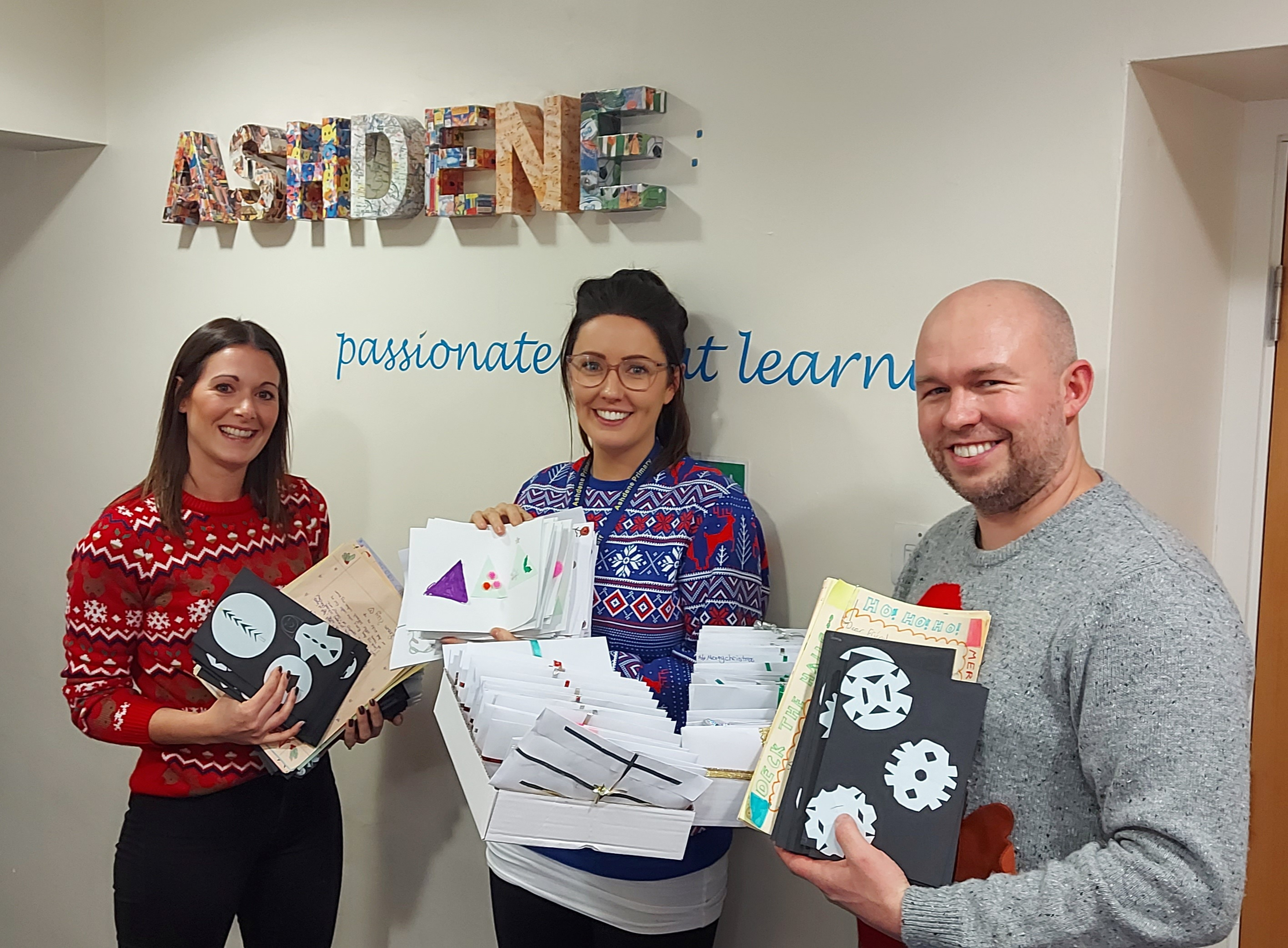 From left to right, Ashdene Primary School teachers Kirsty Gerrity, Laura O’Brien and Headteacher Andy Hayes with the cards and letters written by the pupils at the school for inclusion in the boxes. 
