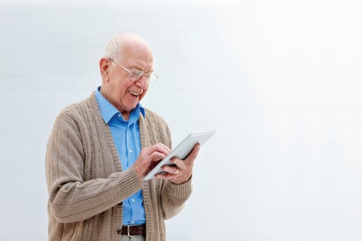 Elderly man holding a tablet