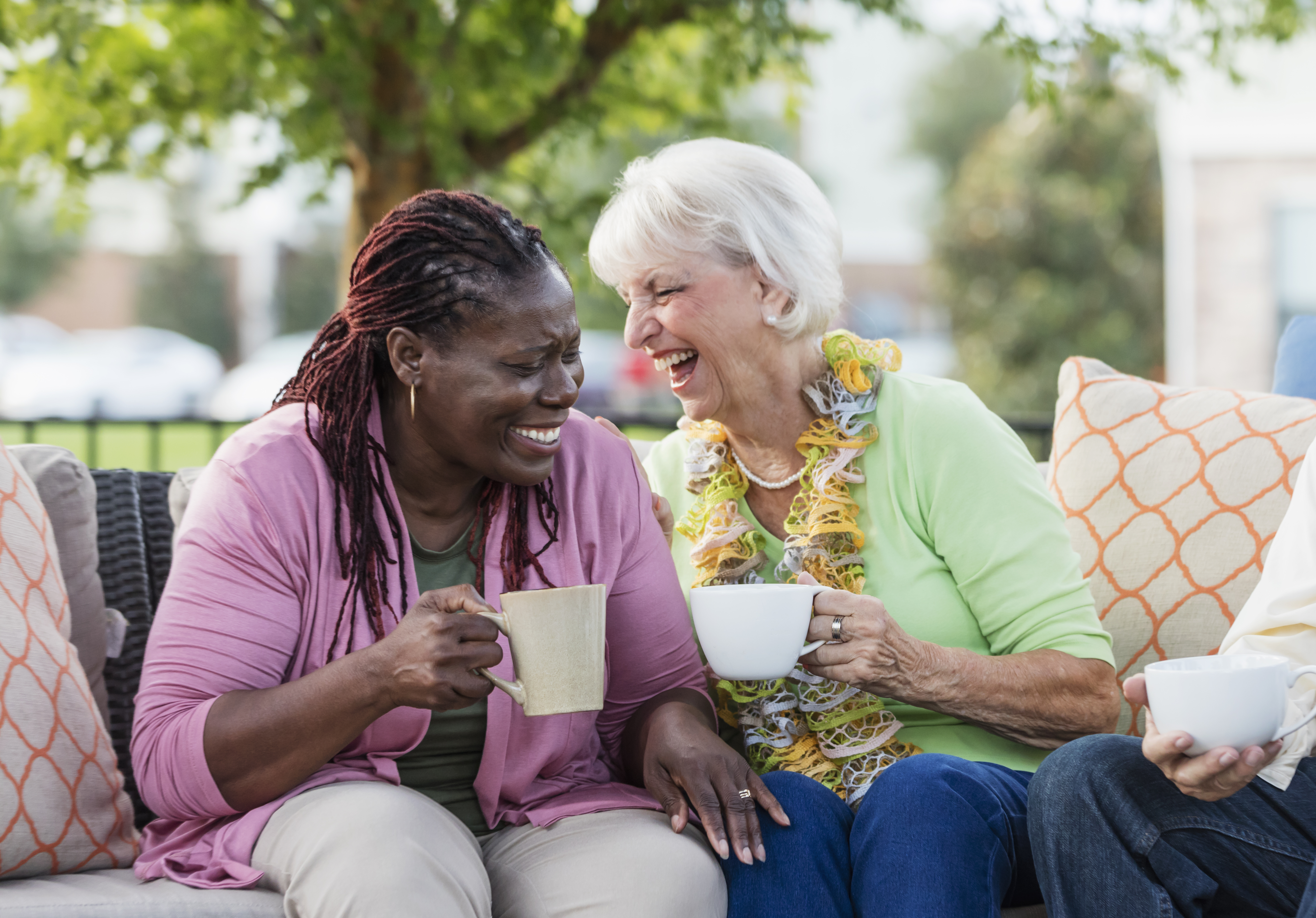 Two ladies laughing over cup of tea