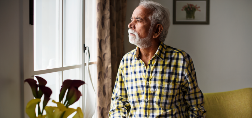 man looking worried as he looks out of a window