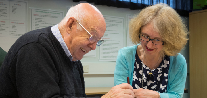 woman helping man to fill a form