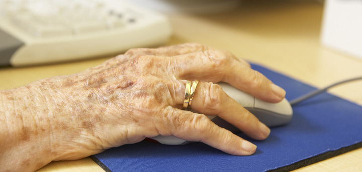 Elderly woman's hand using computer mouse