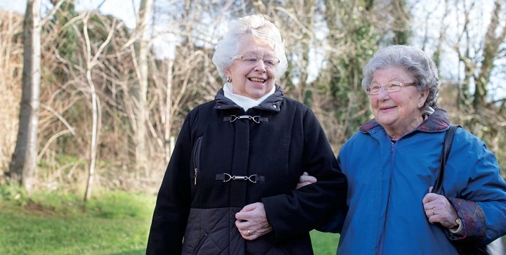 Two ladies walking arm in arm