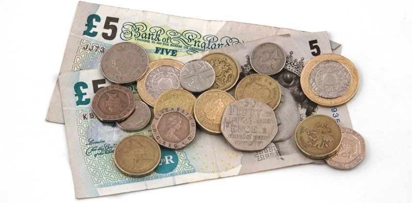 A picture of two five pounds notes with pound coins and silver change on a white background