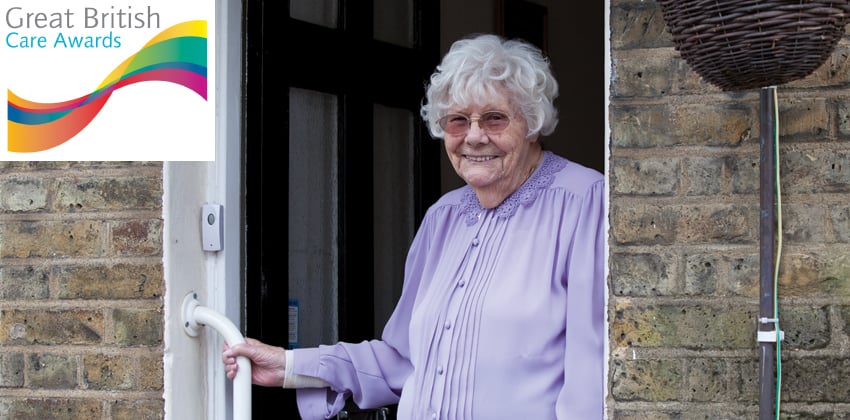 Our Home Care Service An older woman standing smiling in the doorway to her house