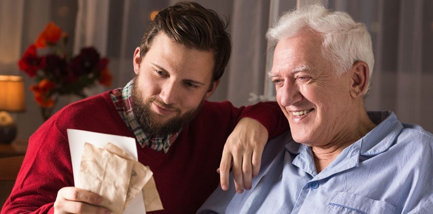 Younger man going through old letters and memories with an older man