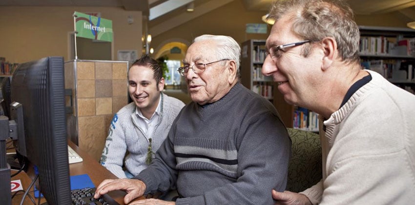 Join our digital skills classes An older man being shown how to make the most of a computer