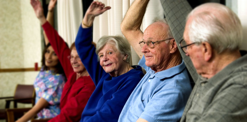 Older people performing gentle seated exercises