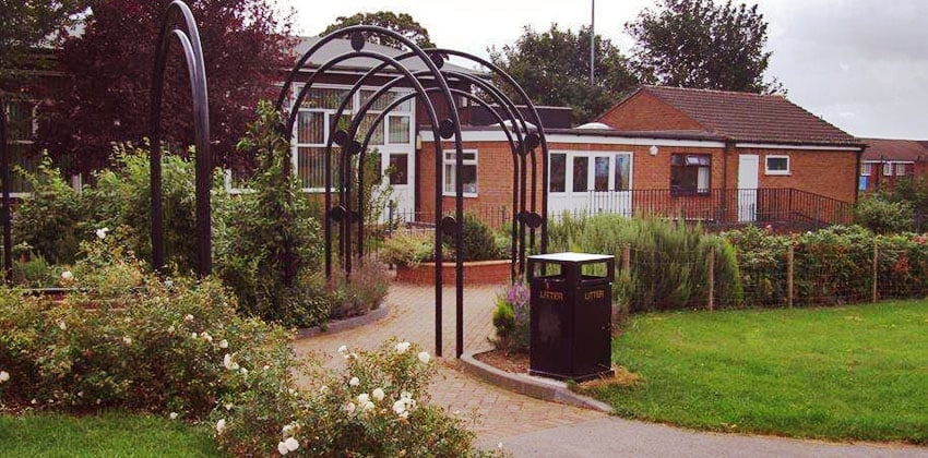 View of the centre framed by yellow rose bushes