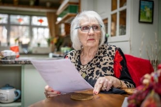 Lady at table looking at bill 