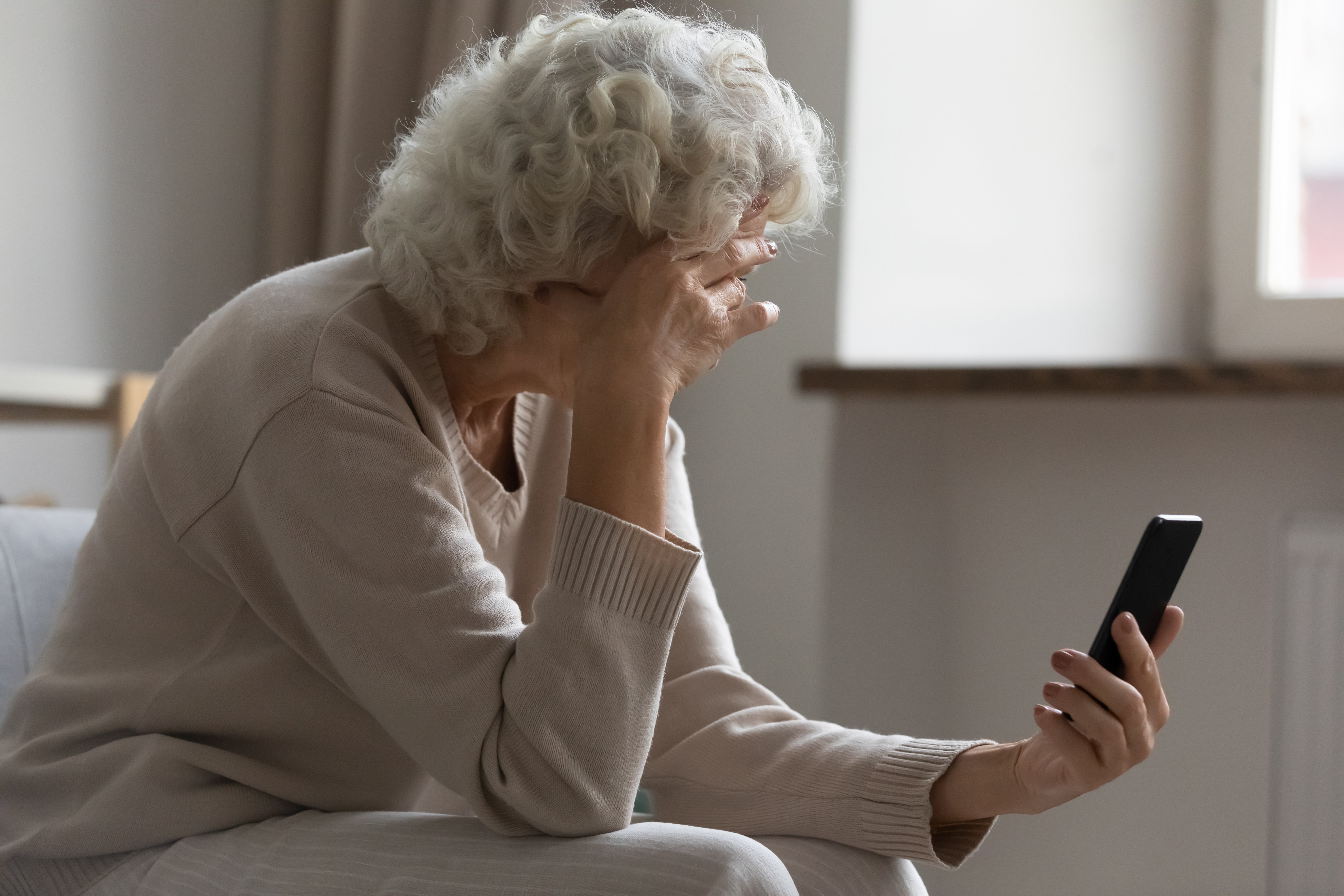 lady with hand to head with mobile in hand