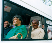Old people on a bus smiling
