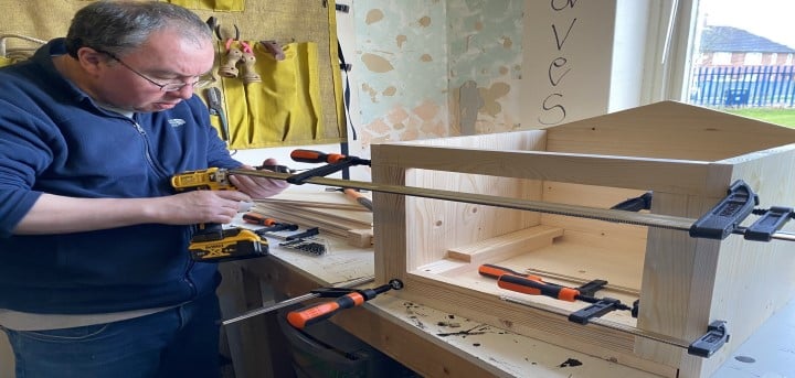 Older gentleman working on a wood-work project.