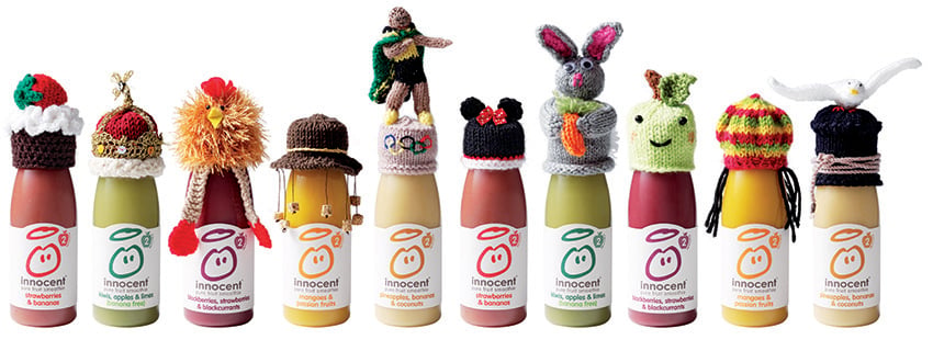 innocent smoothie bottles with a variety of knitted hats
