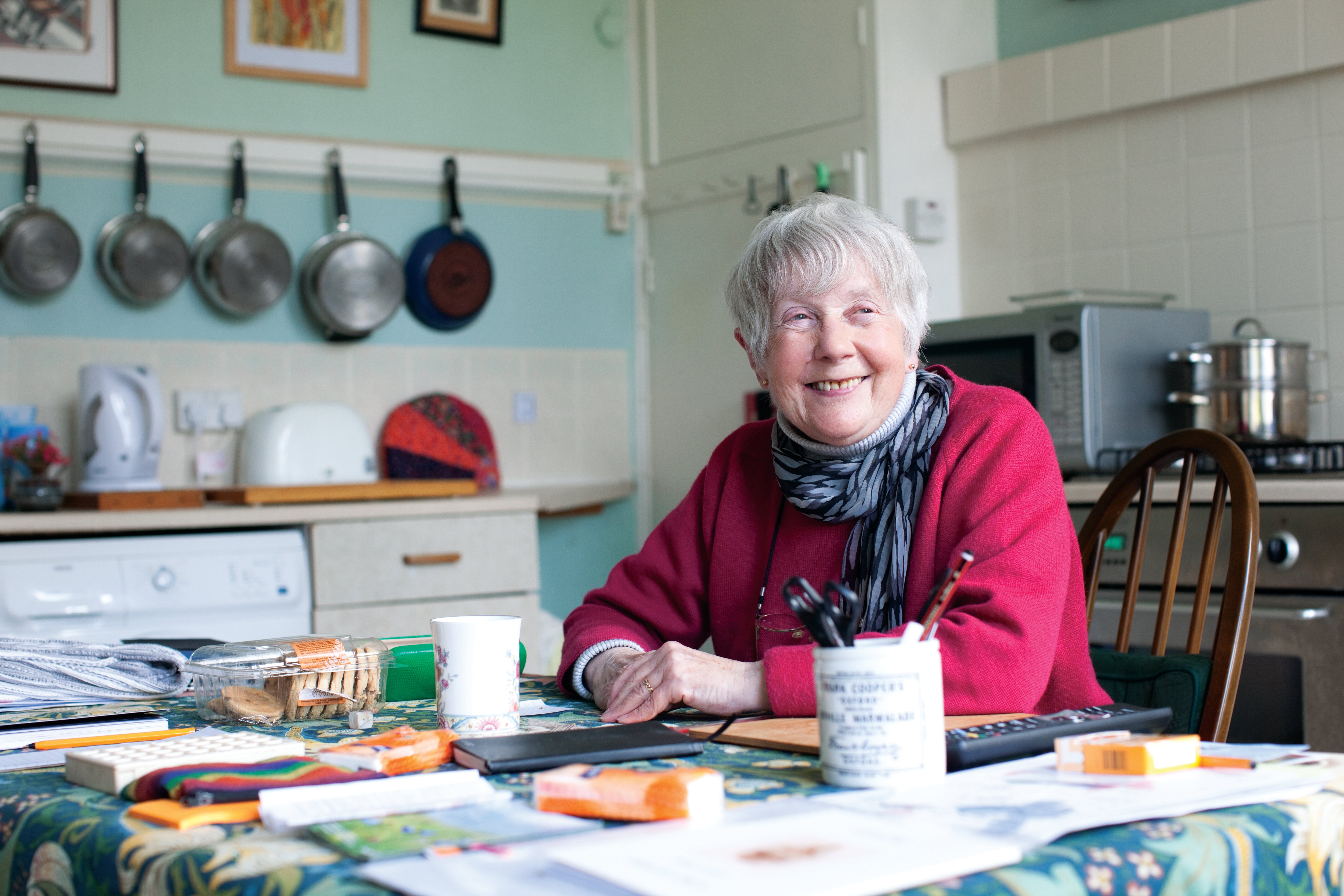 A woman sitting at the kitchen table smiling