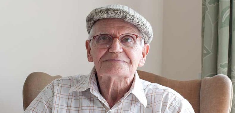 man with flat cap at home