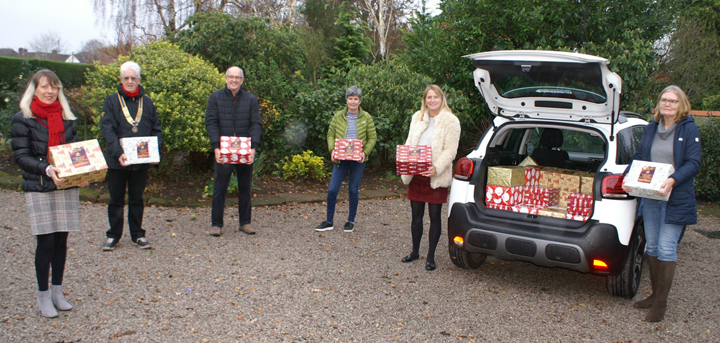 Rotarians Maria Jones, John Law, John Yeomans presenting the hampers to Susan Tonkin, Rachel Rich and Lindsey Kelly.