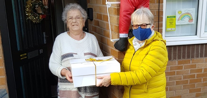 Volunteer Lynne delivering a Christmas hamper to an older person