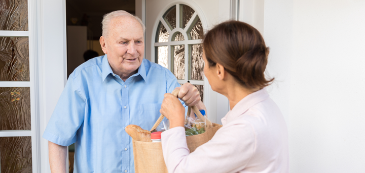 Woman handing an older man a shopping bag
