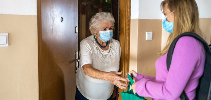 Older woman receiving a shopping delivery at her front door