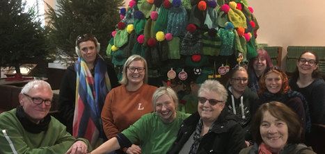 Castlefields Yarn Bombing Crew in front of their decorated Christmas tree