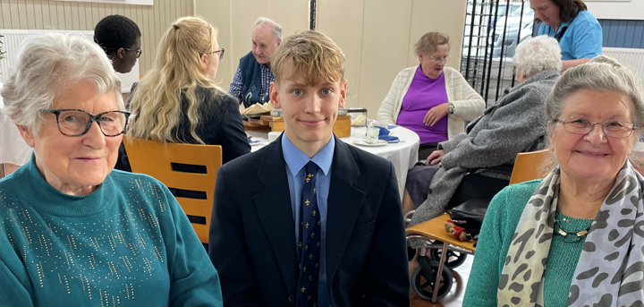 Older people and Shrewsbury School students enjoying afternoon tea