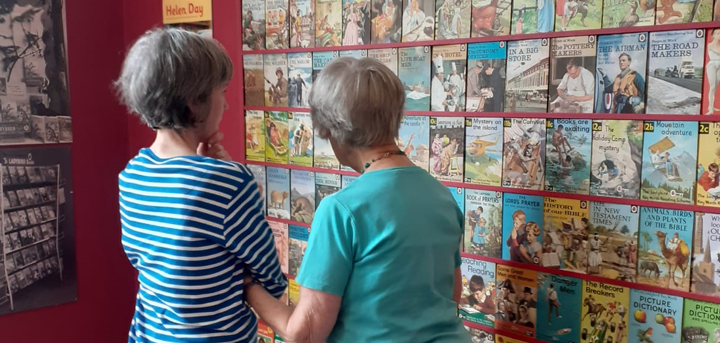Two older women looking at a display of Ladybird book covers