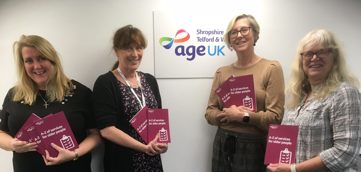 Age UK Shropshire Telford & Wrekin staff holding copies of the new A-Z of Services for Older People