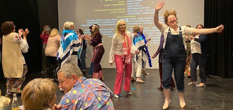 People in fancy dress dancing at a screening of Mamma Mia