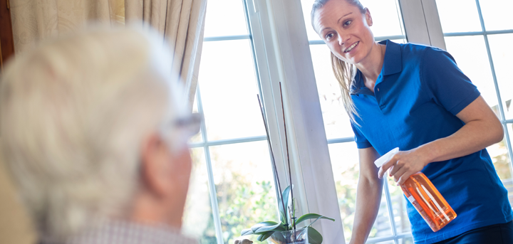 Younger woman cleaning an older person's home