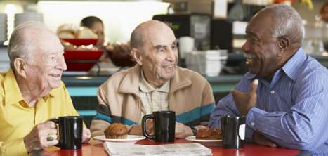 Older men sat chatting round a cafe table