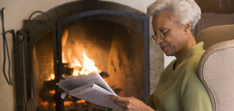 Older woman by an open fire