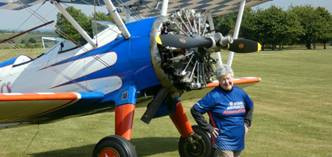 Christine Grundy standing by the biplane she used for her wing walk