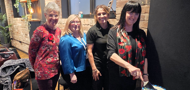 Anne Wignall cutting a cake at the Age UK Shropshire Telford & Wrekin AGM in November
