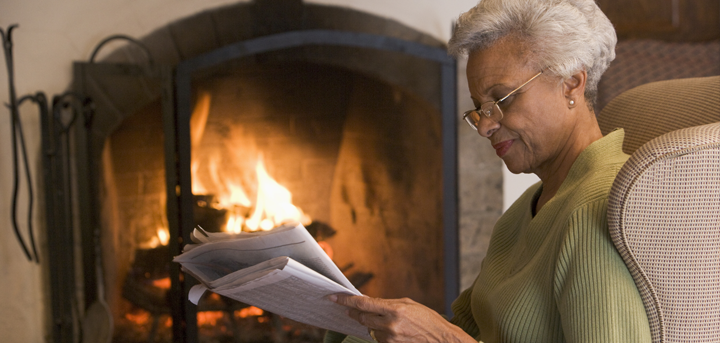 Older woman by an open fire