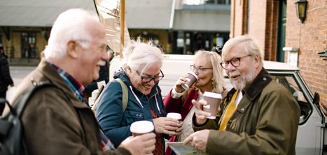 A group of older coffee drinkers outside