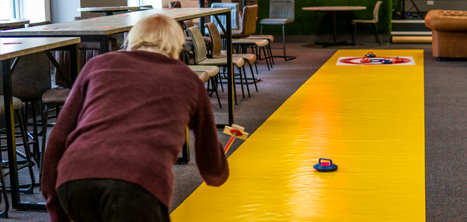 An older person trying indoor curling