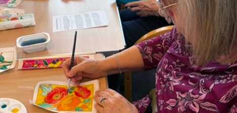 A member of the Coffee and Crafting Club trying silk painting