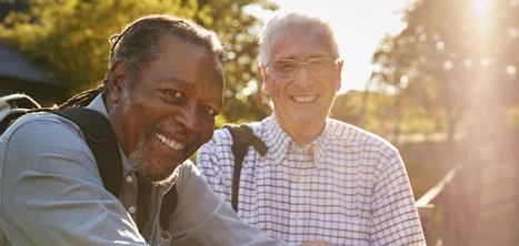 Two older men outside in the sunshine