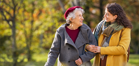 Two women walking near trees