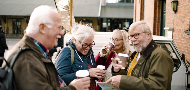 A group of older coffee drinkers outside